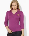 Sleek gold-toned buttons and a metallic embroidered crest lend regal elegance to a soft cotton polo shirt.