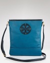 A leather logo plaque details this Tory Burch handbag, offering a distinctive counterpart to its cool, casual crossbody design.