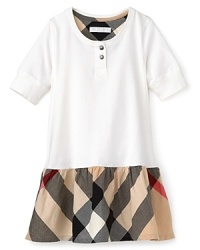 A check printed ruffle at the hem adds a playful girlish touch to a classic Burberry dress, crafted in the softest cotton jersey. A check printed ruffle at the hem adds a playful girlish touch to a classic Burberry dress, crafted in the softest cotton jersey.