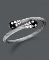 Wrap your wrists in polished perfection. This coil-shaped bangle bracelet features black onyx beads (12 mm) set in stainless steel. Approximate length: 8 inches.