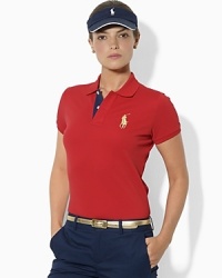 A slim-fitting mesh polo shirt is finished with shimmering metallic details for a feminine update on a classic styling piece. A slim-fitting mesh polo shirt is finished with shimmering metallic details for a feminine update on a classic styling piece.