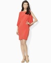 A sleek jersey sheath dress is finished with cascading ruffles at the sides for a romantic look.