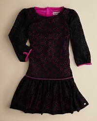 Sweetly dramatic, this drop-waist dress layers dark lace over a hot-pink underlay and finishes it with hot-pink piping. Sweetly dramatic, this drop-waist dress layers dark lace over a hot-pink underlay and finishes it with hot-pink piping.