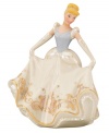 With her long gloves, flowing gown and baby-blue headband, Cinderella waltzes into your home with enchanting beauty. The Disney figurine's magnificent porcelain skirt is embellished with the scene of her escape, featuring the magic pumpkin coach in dazzling 24-karat gold.