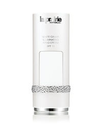 La Prairies White Caviar Illuminating Systeme brightens your skin with an innovative approach to controlling the appearance of discoloration, while offering the legendary benefits of caviar.Unprecedented brightening, supporting and luxury are yours in an illuminating collection so unique you will think of it as a ritual of enlightenment. Imperial caviar, so scarce and desirable it was once reserved for royalty, is at the heart of the White Caviar Illuminating Systeme.Hands have the tendency to betray your age, sometimes appearing more aged than the skin of the face. Exposure to the elements may result in age spots, lines and an unappealing dry, weathered look. White Caviar Illuminating Hand Cream SPF 15 brightens, refines and hydrates skin for a younger, fresher look while guarding against daily exposure with UVA/ UVB protection. A nourishing conditioner supports nail strength and helps to soften cuticles.The Benefits: Contains brighteners that work on existing age spots by targeting overly-pigmented areas Helps to protect from future discoloration with sunscreens A conditioning treatment helps to strengthen nails and soften cuticlesThe Application:Gently massage a small amount into hands from wrists to fingertips. Dab a small amount onto cuticles and massage each fingertip.Usage: Use AM and PM. La Prairies White Caviar Illuminating Systeme brightens your skin with an innovative approach to controlling the appearance of discoloration, while offering the legendary benefits of caviar.Unprecedented brightening, supporting and luxury are yours in an illuminating collection so unique you will think of it as a ritual of enlightenment. Imperial caviar, so scarce and desirable it was once reserved for royalty, is at the heart of the White Caviar Illuminating Systeme.Hands have the tendency to betray your age, sometimes appearing more aged than the skin of the face. Exposure to the elements may result in age spots, lines and an unappealing dry, weathered look. White Caviar Illuminating Hand Cream SPF 15 brightens, refines and hydrates skin for a younger, fresher look while guarding against daily exposure with UVA/ UVB protection. A nourishing conditioner supports nail strength and helps to soften cuticles.The Benefits: Contains brighteners that work on existing age spots by targeting overly-pigmented areas Helps to protect from future discoloration with sunscreens A conditioning treatment helps to strengthen nails and soften cuticlesThe Application:Gently massage a small amount into hands from wrists to fingertips. Dab a small amount onto cuticles and massage each fingertip.Usage: Use AM and PM.