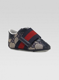 A wide strap in familiar Gucci stripes crosses over a refined sneaker of double G fabric with rich leather accents.GG fabric upperLeather toe, back and accentsWide, striped grip-tape close strapRubber soleMade in Italy