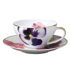 Pensees tea saucer by Bernardaud. This lively, luxurious saucer is sure to transform your table into a celebration of spring. The floral watercolor pattern features delicate, multicolored pansies that appear to be strewn across the surface of each piece.