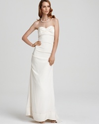 Defining understated elegance, this Nicole Miller strapless gown of supple, satiny silk boasts subtle ruching for visual interest and a flattering fit. Defining understated elegance, this Nicole Miller strapless gown of supple, satiny silk boasts subtle ruching for visual interest and a flattering fit.