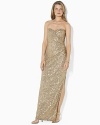 A stunning foundation of sequins imparts sexy sophistication to a sweeping floor-length gown, designed in a sleek faux-wrap silhouette with elegant ruching and a dramatic slit at the hem.