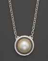 A cultured freshwater pearl is framed in a sterling silver & 24K gold setting with an ornate, organic feel. From Gurhan.