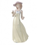 A picture-perfect still of grace and beauty, this handmade porcelain figure presents a young belle admiring a flower as her dress flutters behind; an ideal gift that sparks care-free joy within any special someone.