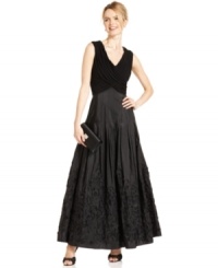 Patra's classic gown is decked out with contrasting textures at the bodice and skirt and a scroll-like applique from knee to hem. Patra's classic gown is decked out with contrasting textures at the bodice and skirt and a scroll-like applique from knee to hem.