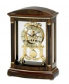 A regal finishing touch for the mantel. This solid wood clock by Bulova is finished in dark wine and features an ornate gold tone dial and gears covered by a glass lens.