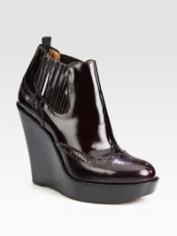 A stacked wedge heightens this patent leather ankle boot, with traditional perforated details and elasticized panels. Stacked wedge, 4¾ (120mm)Stacked platform, 1¼ (30mm)Compares to a 3½ heel (90mm)Patent leather upperPull-on style with side elastic panelsLeather liningRubber solePadded insoleMade in Italy