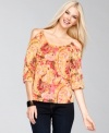 Cutout shoulders enhance a pretty printed peasant top from INC.