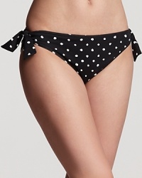 Channel pin-up glamour poolside in Tommy Bahama's spot-splashed bikini. In a dotty print and retro cut, this reversible bottom is a versatile choice with a classic side.