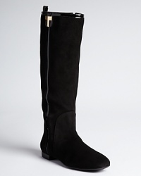 Patent insets lend a subtle sheen to Tory Burch's Erica boots, adorned with a gilded gold-tone T. Patent insets lend a subtle sheen to Tory Burch's Erica boots, adorned with a gilded gold-tone T.