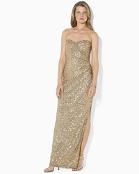 A stunning foundation of sequins imparts sexy sophistication to a sweeping floor-length gown, designed in a sleek faux-wrap silhouette with elegant ruching and a dramatic slit at the hem. A stunning foundation of sequins imparts sexy sophistication to a sweeping floor-length gown, designed in a sleek faux-wrap silhouette with elegant ruching and a dramatic slit at the hem.