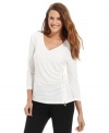 Calvin Klein adds urban appeal to this V-neck top with a shiny gold zipper at the side.