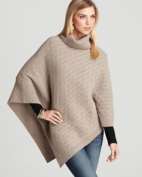 With a long triangle hem, Aqua's cable knit poncho looks flawless over printed leggings and a pair of booties. With a long triangle hem, Aqua's cable knit poncho looks flawless over printed leggings and a pair of booties.