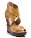 Chic strappy leather sandals with a sculptural wedge for a modern touch.