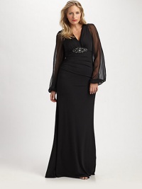 This stunning gown was designed to accentuate your shape, thanks to a striking embellishment at a subtly gathered bust and sheer sleeves offering glamorous arm coverage.V-necklineSheer, bell sleevesEmbellishment at gathered bustConcealed back zipperFully linedAbout 45 from natural waist95% polyester/5% spandexDry cleanMade in USA of imported fabric This stunning gown was designed to accentuate your shape, thanks to a striking embellishment at a subtly gathered bust and sheer sleeves offering glamorous arm coverage.V-necklineSheer, bell sleevesEmbellishment at gathered bustConcealed back zipperFully linedAbout 45 from natural waist95% polyester/5% spandexDry cleanMade in USA of imported fabric