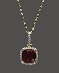 Diamonds frame a faceted garnet, set in 14K yellow gold. Diamonds frame a faceted garnet, set in 14K yellow gold.