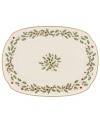 Perfect for entertaining, this large platter is trimmed with gold and a holly motif to match the beloved Lenox Holiday dinnerware collection.