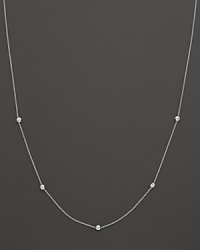 A white gold chain with five bezel-set diamond stations.