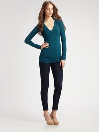 Body-skimming stretch knit, finished with layered shrug shoulders.V neckline Long sleeves Ruched back panels About 28 from shoulder to hem 94% rayon/6% spandex Dry clean Made in USA Body-skimming stretch knit, finished with layered shrug shoulders.V neckline Long sleeves Ruched back panels About 28 from shoulder to hem 94% rayon/6% spandex Dry clean Made in USA