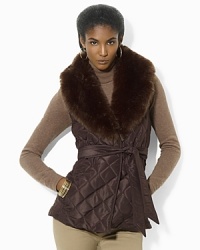 A quilted vest evokes equestrian style with a belted waist and luxurious trimmed collar for added elegance. A quilted vest evokes equestrian style with a belted waist and luxurious trimmed collar for added elegance.