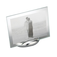 Accommodating either a vertical or horizontal photo, this rectangular photo frame consists of an oval base made of Nambé alloy and two sheets of glass to enclose a photo. The Nambé alloy base is solid and stable. Designed by Neil Cohen.