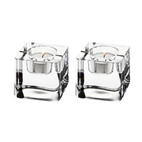 Paired with simple votive candles, this set of charming cube-shaped Orrefors candleholders evoke the look of fire and ice in pure, sparkling crystal. Paired with simple votive candles, this set of charming cube-shaped Orrefors candleholders evoke the look of fire and ice in pure, sparkling crystal.