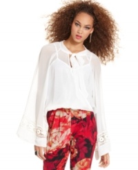 Sheer beauty: a dreamy layer of chiffon wraps delicately at the bodice, while bell sleeves and a tie at the neck bring feminine spirit to this top from XOXO. Sheer beauty: a dreamy layer of chiffon wraps delicately at the bodice, while bell sleeves and a tie at the neck bring feminine spirit to this top from XOXO.