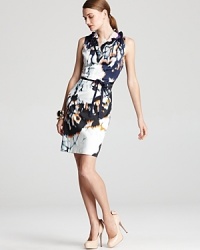 A vivid blaze of abstract print ignites this sleek Elie Tahari dress, finished with a decadent ruffled collar for modern femininity. A vivid blaze of abstract print ignites this sleek Elie Tahari dress, finished with a decadent ruffled collar for modern femininity.