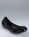 A wax-seal inspired logo takes form at the toe of Tory Burch's Caroline flats, rendered in patent leather with elastic trim.