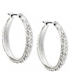 Stylish with a classic aesthetic. Enchanting crystal pave accents add flair to these oval hoop earrings from Jones New York. Crafted with worn silver tone mixed metal. Approximate drop: 1-1/4 inches. Approximate diameter: 1 inch.