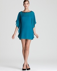 Dolman flutter sleeves lend a caftan-like look to a chiffon Trina Turk dress, dressed up with a beaded neckline. Dolman flutter sleeves lend a caftan-like look to a chiffon Trina Turk dress, dressed up with a beaded neckline.