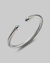 From the Color Classics Collection. A graceful sterling silver cable, capped with faceted blue topaz domes and accents of 14k gold. Blue topaz Sterling silver and 14k yellow gold Cable, 5mm Diameter, about 2¼ Imported