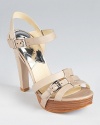 Resting atop a stacked platform, the MICHAEL Michael Kors Grace sandals stand out with stitched details at the heel.