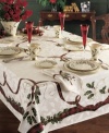 Season's meetings! Traditional holiday motifs of holly and ribbon adorn this durable cotton-blend tablecloth. A festive addition to your holiday décor you'll use year after year.