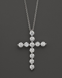 Faceted diamonds set in a gleaming 18K white gold cross. Faceted diamonds set in a gleaming 18K white gold cross.