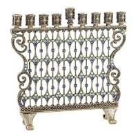 A luxe essential for celebrating the holidays, this menorah glitters with hundreds of blue and green hand-set Swarovski® crystals set in antiqued brass. A luxe essential for celebrating the holidays, this menorah glitters with hundreds of blue and green hand-set Swarovski® crystals set in antiqued brass.