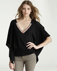 An ornately beaded neckline adds panache to this Velvet by Graham & Spencer top, fashioned in a billowy caftan-like silhouette. An ornately beaded neckline adds panache to this Velvet by Graham & Spencer top, fashioned in a billowy caftan-like silhouette.