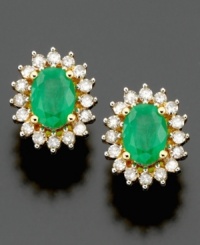 Shining stud earrings bursting with brilliance. Oval-cut emerald (1/2 ct. t.w.) and round-cut diamond (1/2 ct. t.w.) are set in 14k gold. Approximate length: 1/2 inch.