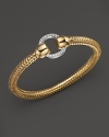 Sparkling diamonds decorate a gleaming 18K gold Roberto Coin bracelet.