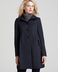 A flattering empire waist with pleating detail lets you face the rain in effortless style in this DKNY coat--complete with a detachable hood to keep you dry. A flattering empire waist with pleating detail lets you face the rain in effortless style in this DKNY coat--complete with a detachable hood to keep you dry.