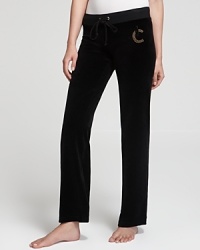 Rhinestone embellishment glams up your classic Juicy Couture velour pants for a luxe approach to laidback style. Rhinestone embellishment glams up your classic Juicy Couture velour pants for a luxe approach to laidback style.
