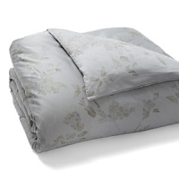 A soft floral in muted blue and taupe is scattered across a silvery grey background in this collection from Calvin Klein Home. A soft floral in muted blue and taupe is scattered across a silvery grey background in this collection from Calvin Klein Home.