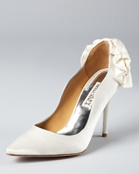 A draped velvet bow details the back of the Badgley Mischka Wysdom II pumps, while a curving, wavy collar adds a unique touch. A draped velvet bow details the back of the Badgley Mischka Wysdom II pumps, while a curving, wavy collar adds a unique touch.